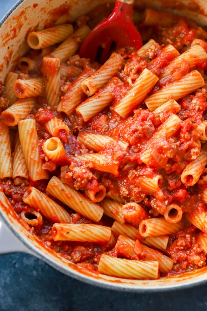 Making rigatoni al forno in a large pot with homemade sauce and cheese