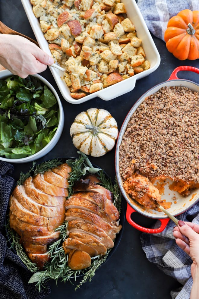 Serving side dishes at a Thanksgiving dinner table