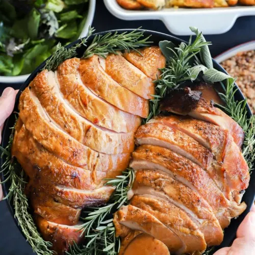 holding a plate of sliced meat for the Thanksgiving table