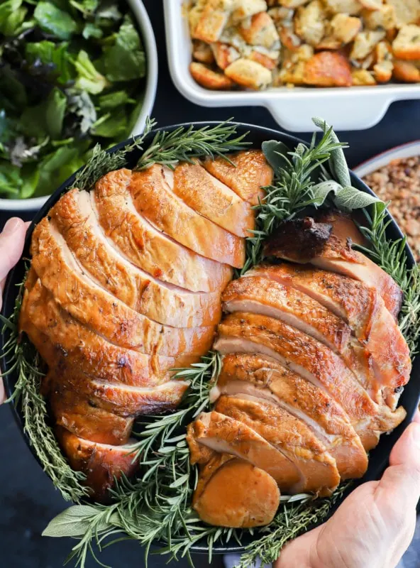 holding a plate of sliced meat for the Thanksgiving table