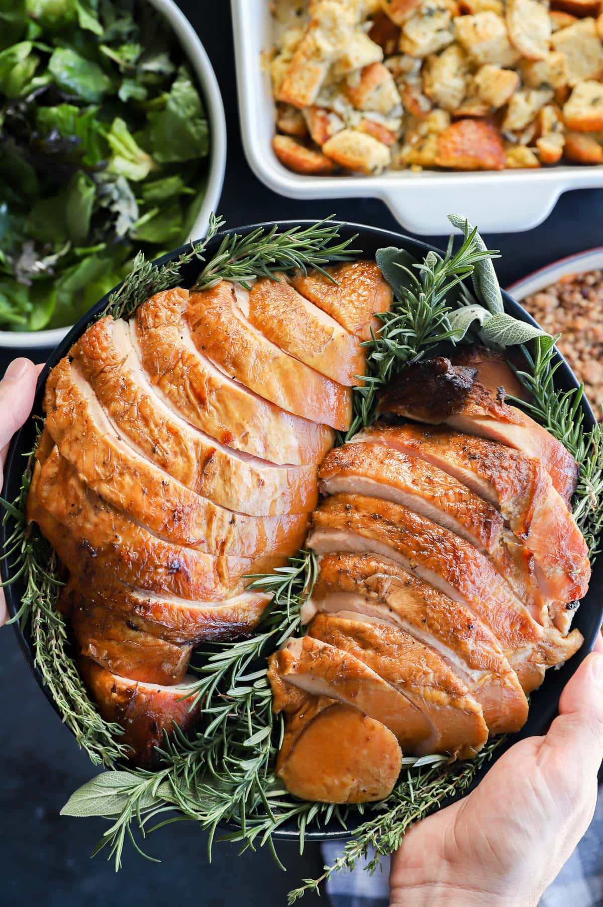 holding a plate of sliced meat for the Thanksgiving table