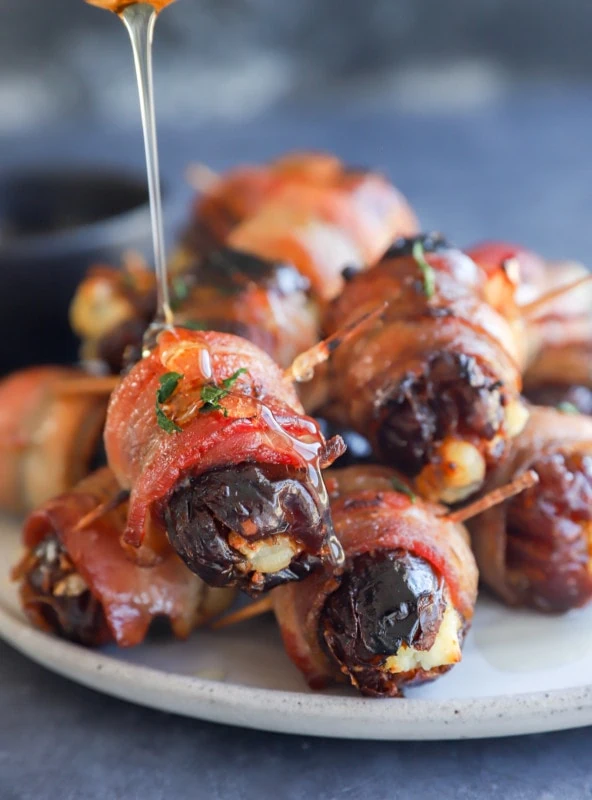 Drizzling honey over the bacon wrapped dates