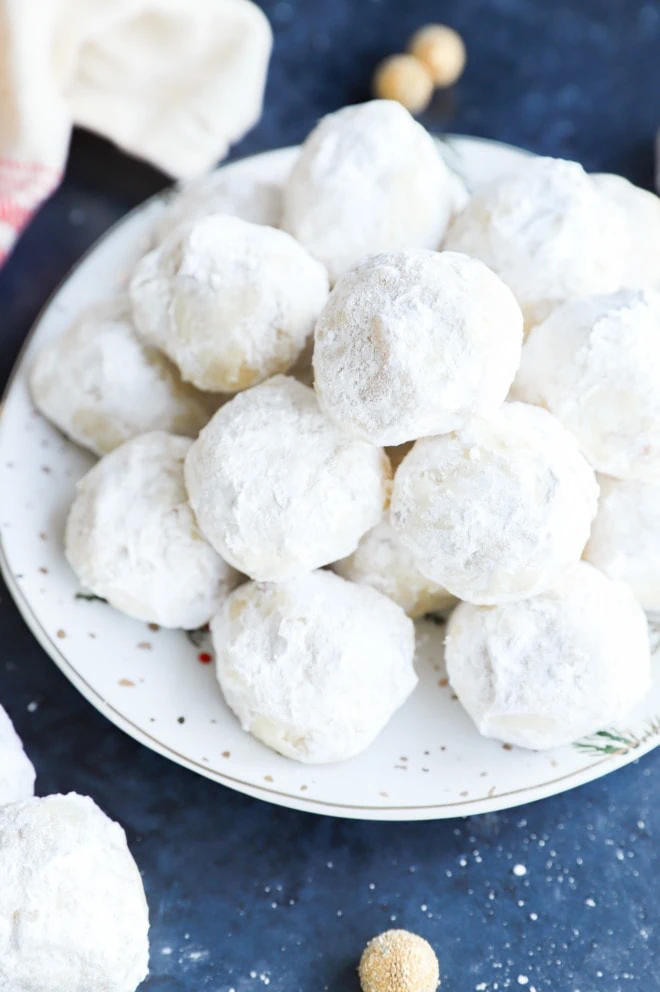 Plate of a pile of russian tea cakes with powdered sugar