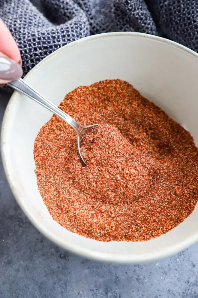 stirring together bbq chicken rub in bowl