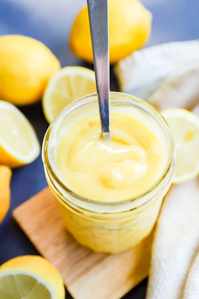 Creamy smooth jam in a mason jar with fruit all around