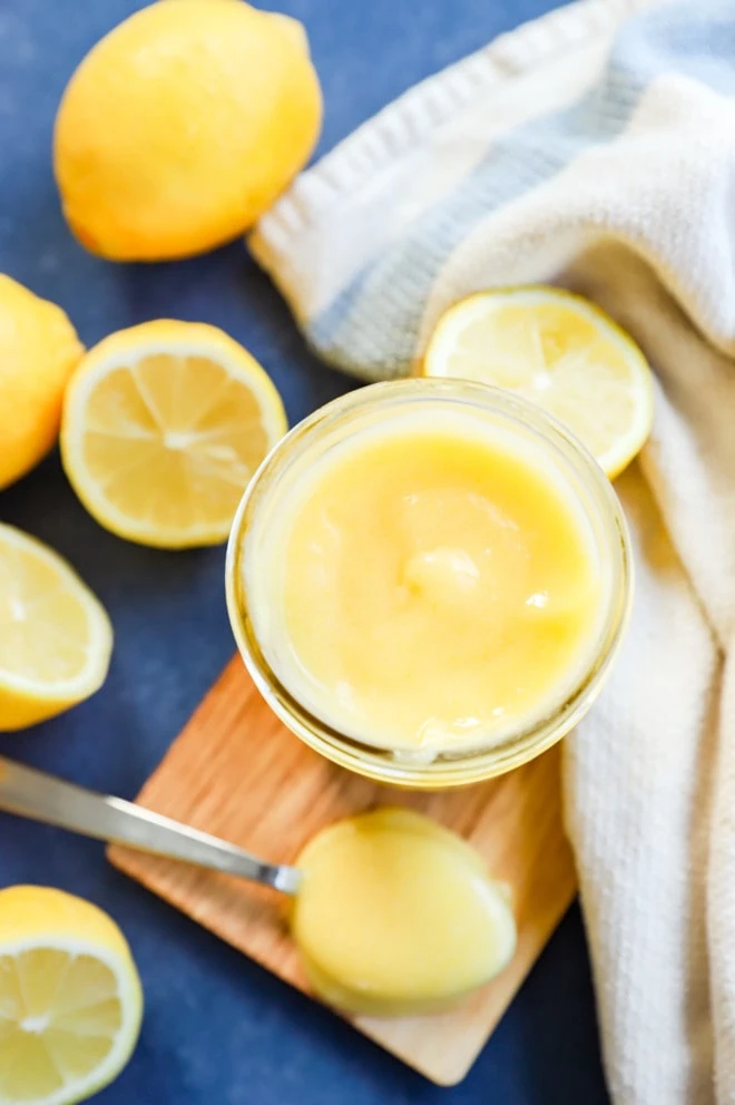 Lemons all around with lemon curd in a jar with a spoon