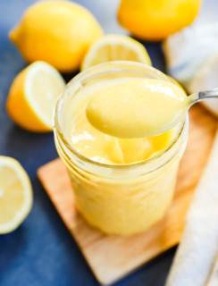Spooning out a creamy sauce with fruit all around