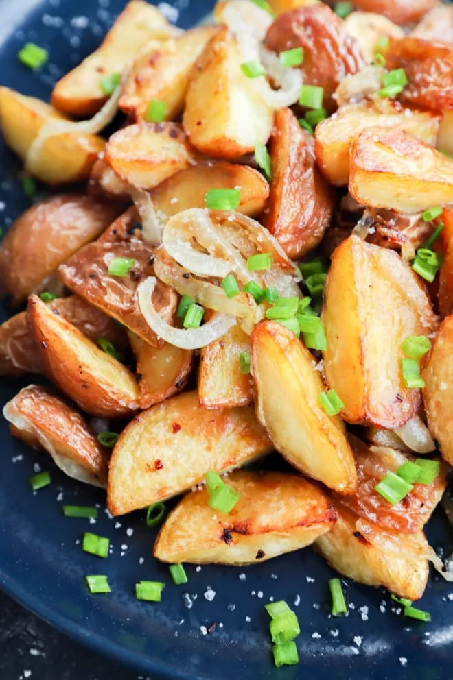 Chives on top of fried potatoes and onions made in the oven