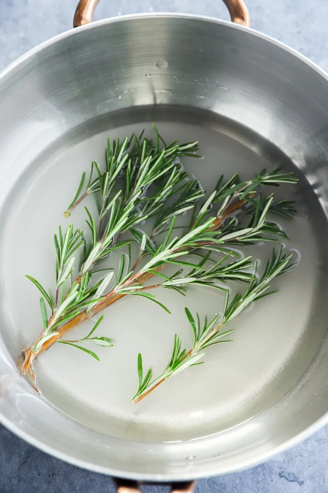 making rosemary simple syrup in a saucepan