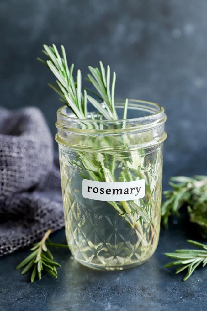 rosemary simple syrup in a mason jar with fresh herbs