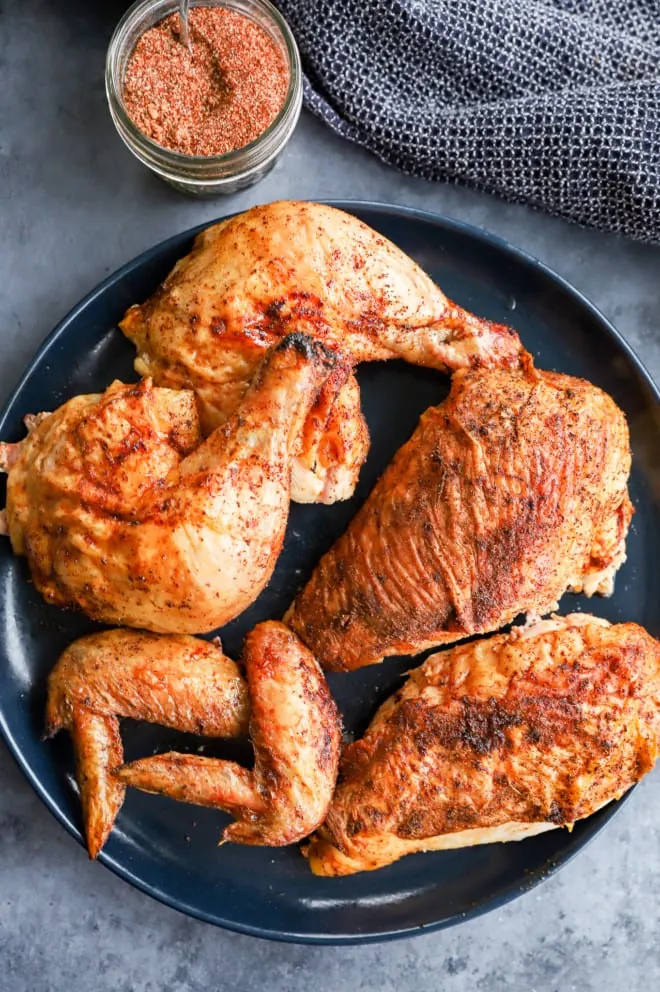 Chicken pieces on a platter with dry rub