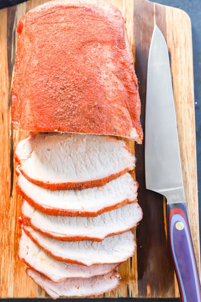 pork loin roast smoked and sliced on cutting board with knife