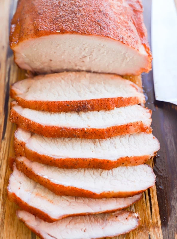 Sliced pork loin on a cutting board with knife