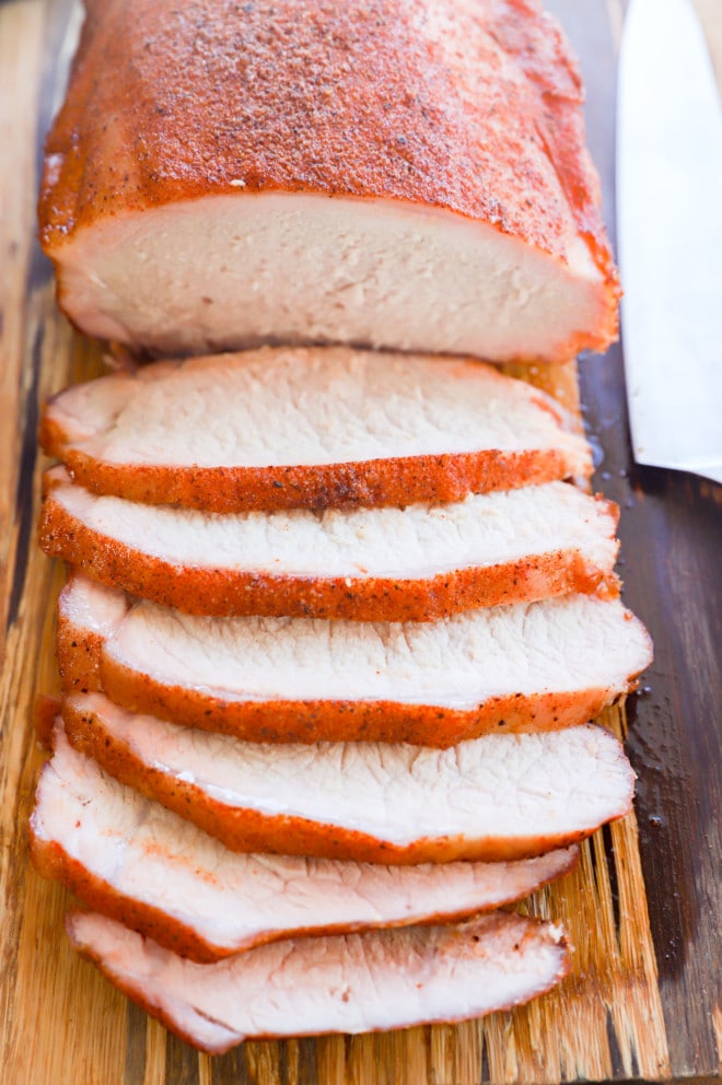 Sliced pork loin on a cutting board with knife