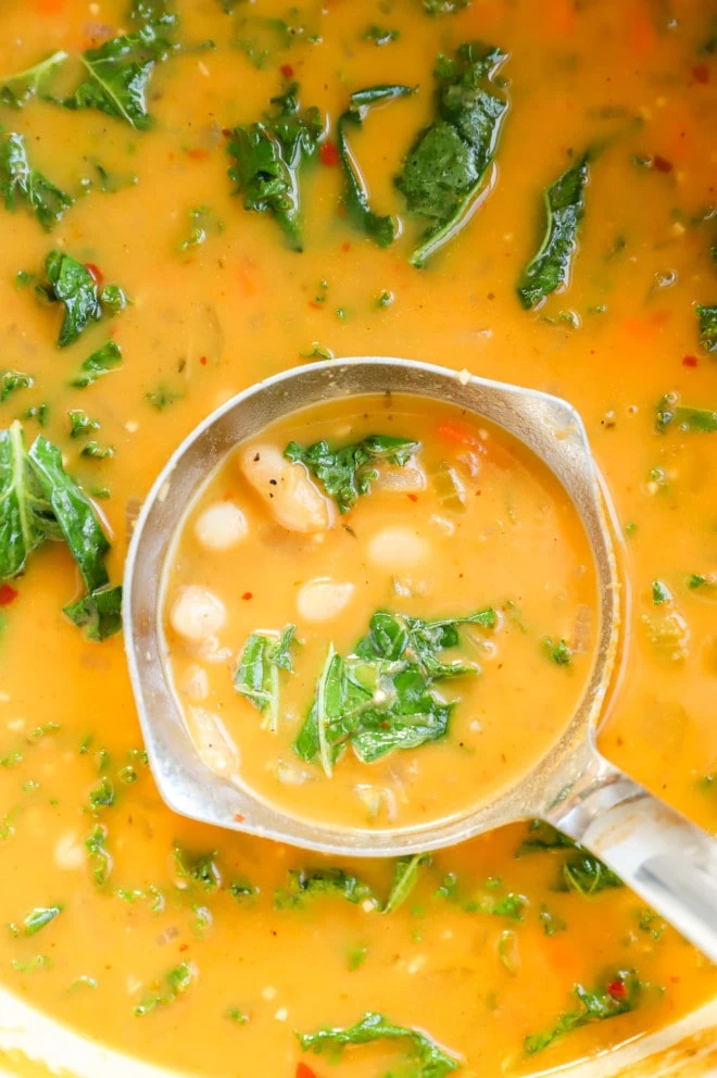 ladling out tuscan white bean soup from pot