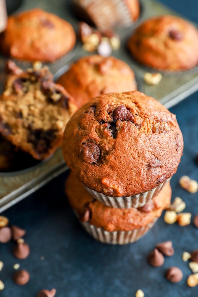 Muffins stacked on top of each other with bananas chocolate and nuts