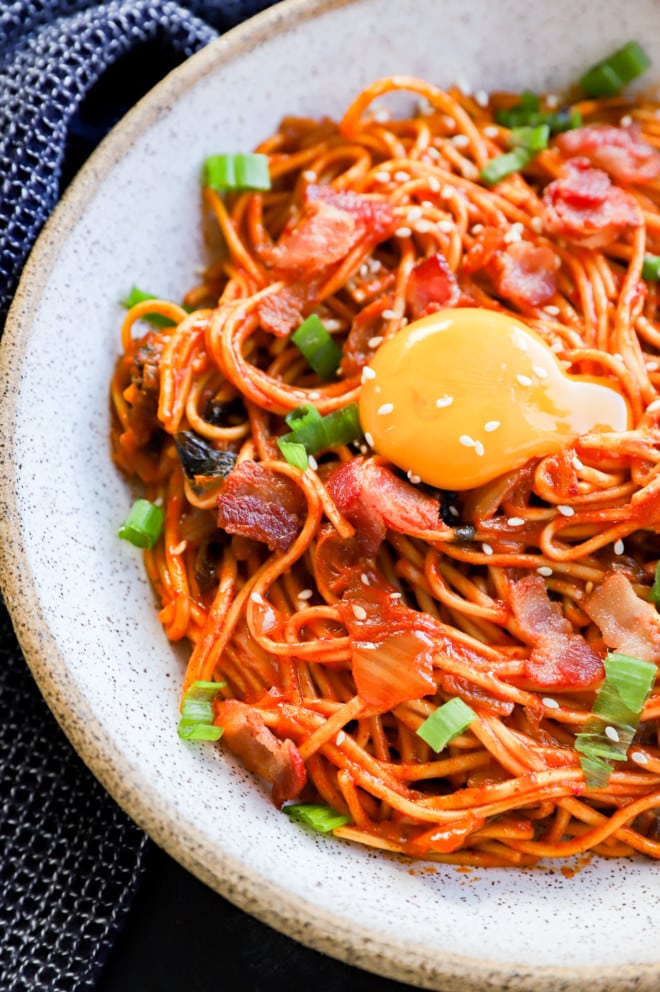 Runny egg yolk over kimchi noodles