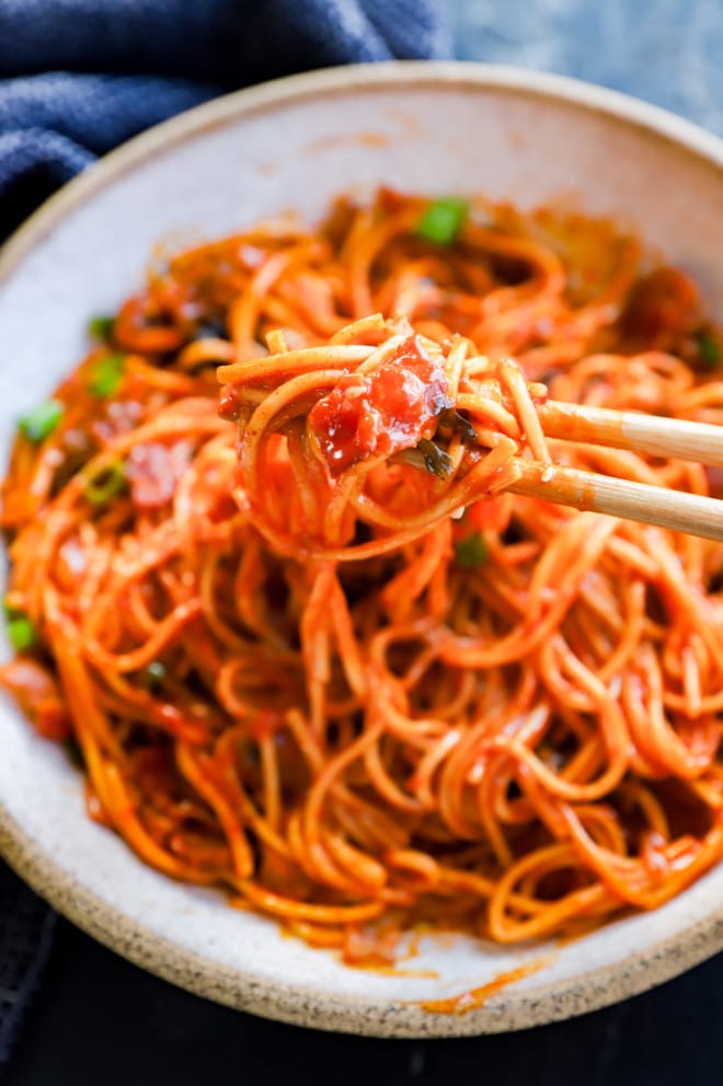 chopsticks picking up spicy noodles