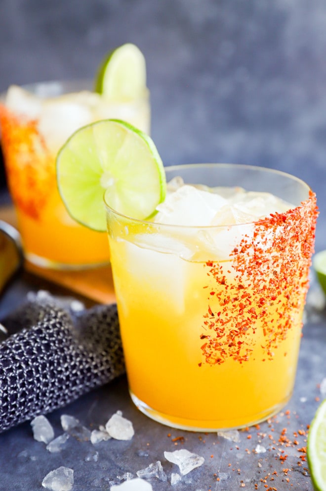 passion fruit margaritas in glasses with tajin rim and lime wheel garnish