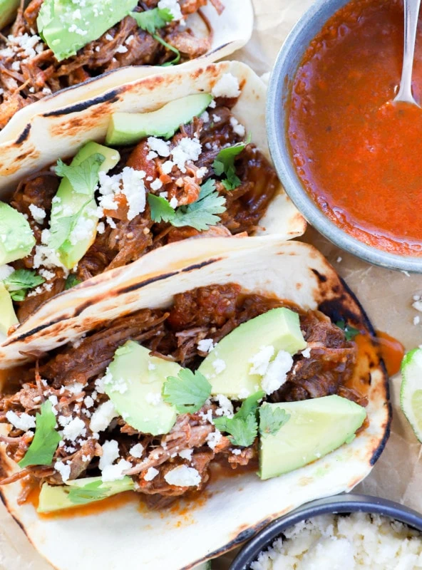 overhead image of shredded beef tacos and toppings