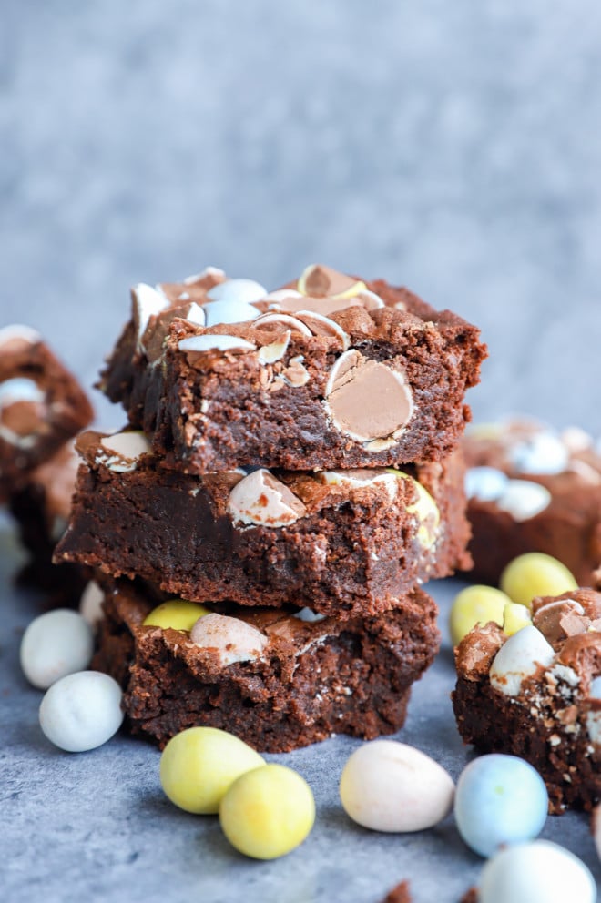 easter brownies in a stack with mini eggs all around