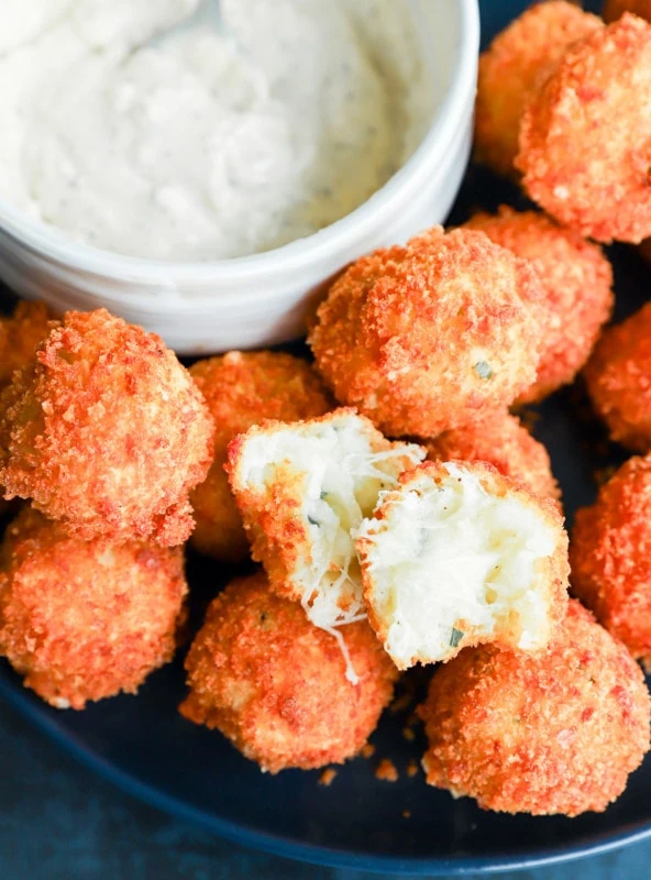 Potato cheese ball torn in half to show the gooey cheese inside