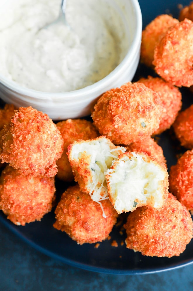 Potato cheese ball torn in half to show the gooey cheese inside