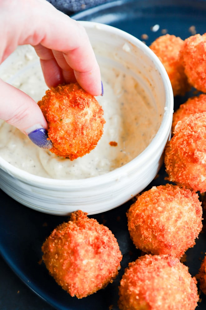 Dipping potato cheese balls in aioli