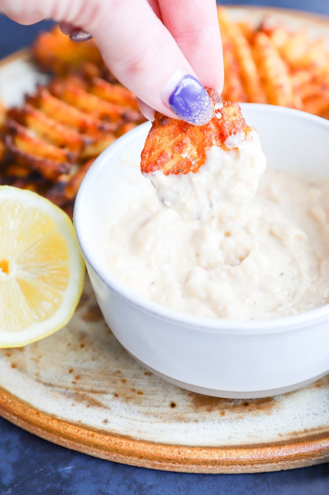 dipping a fry in a savory mayonnaise dip