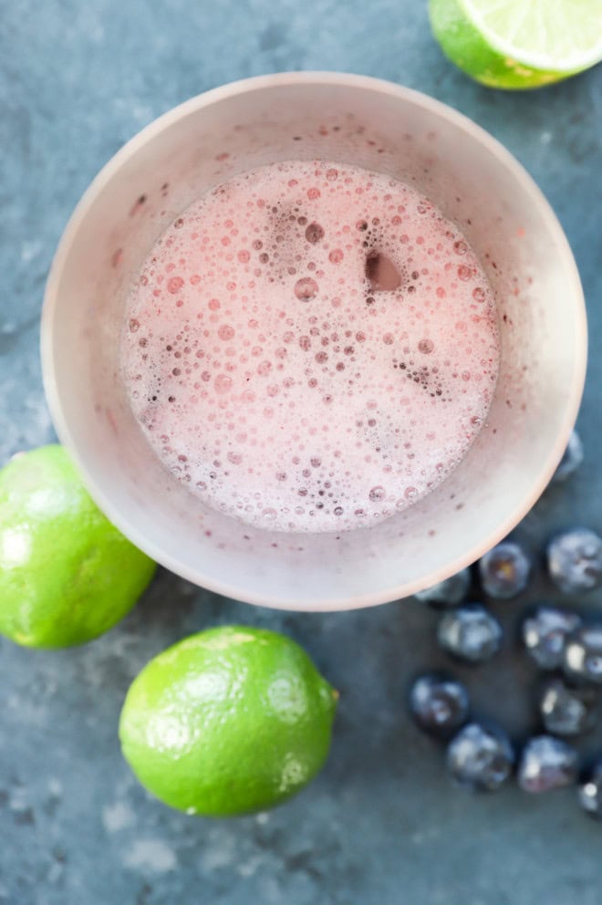 making a blueberry margarita in a cocktail shaker