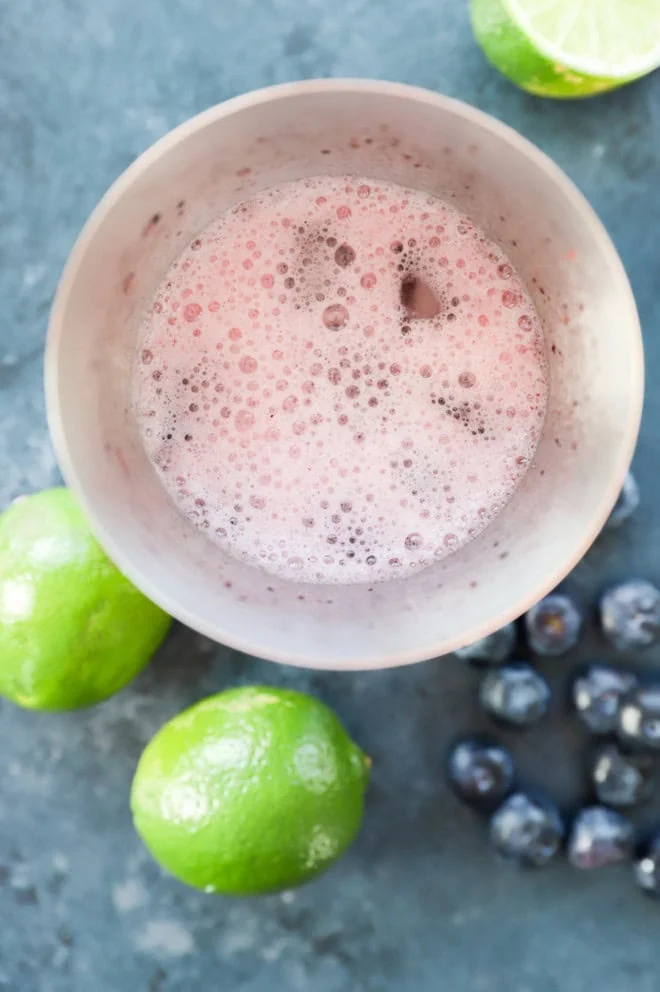 making a blueberry margarita in a cocktail shaker