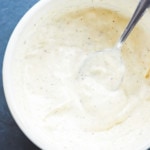 Creamy garlic aioli in a bowl with a spoon
