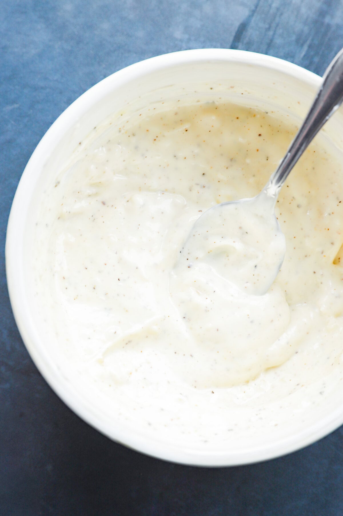 Creamy garlic aioli in a bowl with a spoon