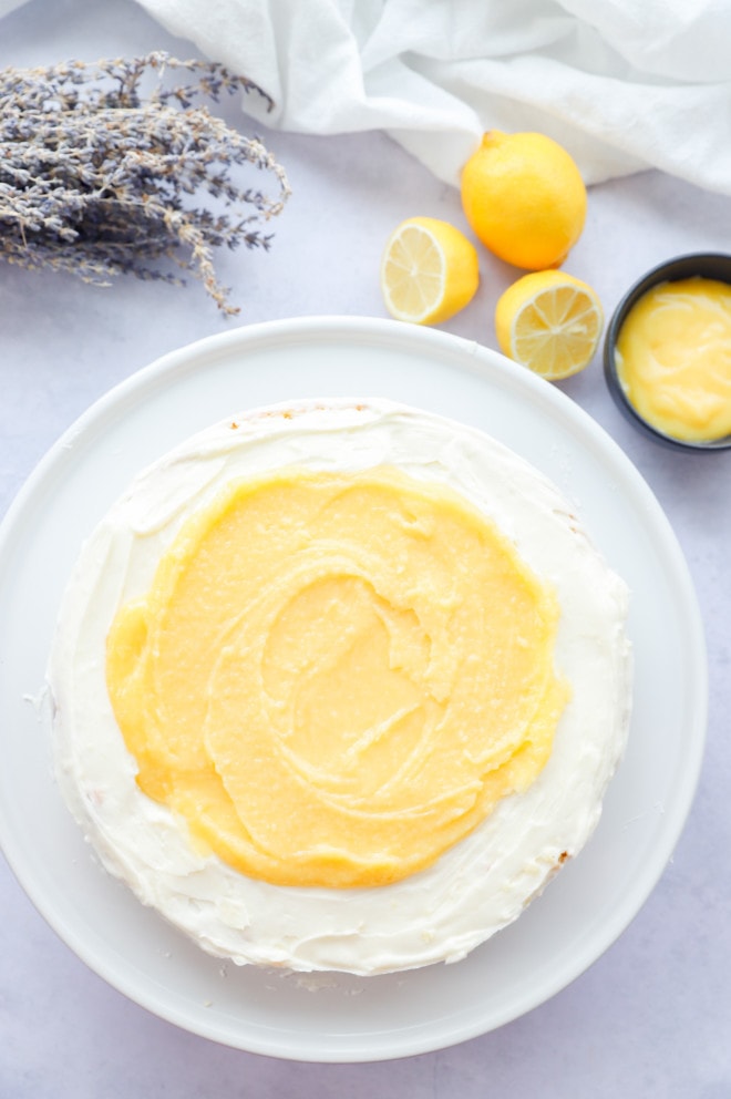 Assembling lemon lavender curd cake on a cake stand