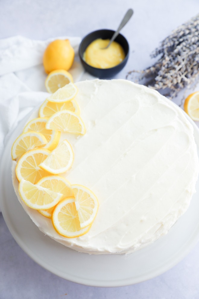 Lavender Lemon Curd Cake on cake stand with lemon slices on top