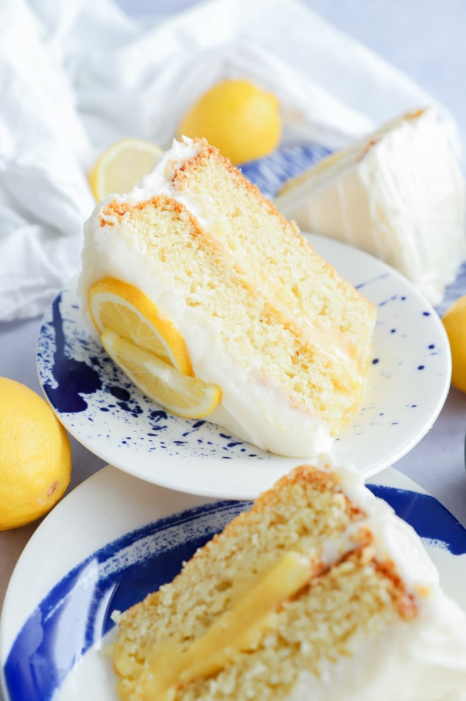 Slices of Lavender Lemon Curd Cake on plates with fresh lemons