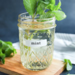 mint simple syrup in a mason jar with fresh mint leaves and sprigs