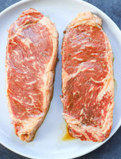 Marinated steaks on a plate new york strip steak