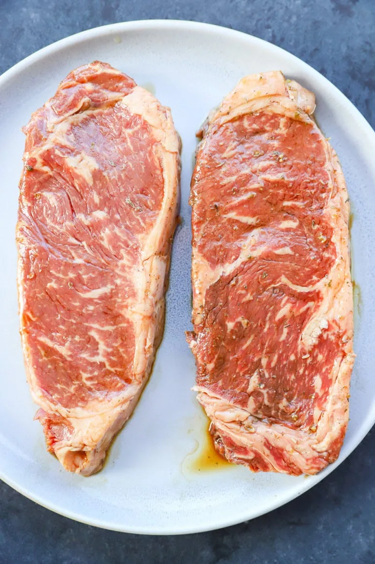 Marinated steaks on a plate new york strip steak
