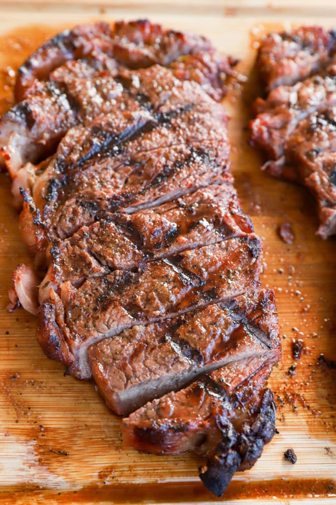 Sliced grilled beef on cutting board ready to be eaten
