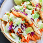 buffalo chicken tacos with cabbage and avocado on top