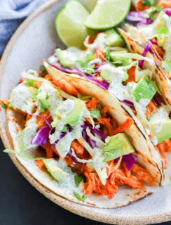 buffalo chicken tacos with cabbage and avocado on top