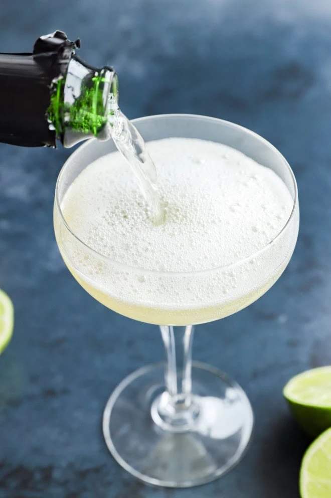 pouring champagne into a coupe glass