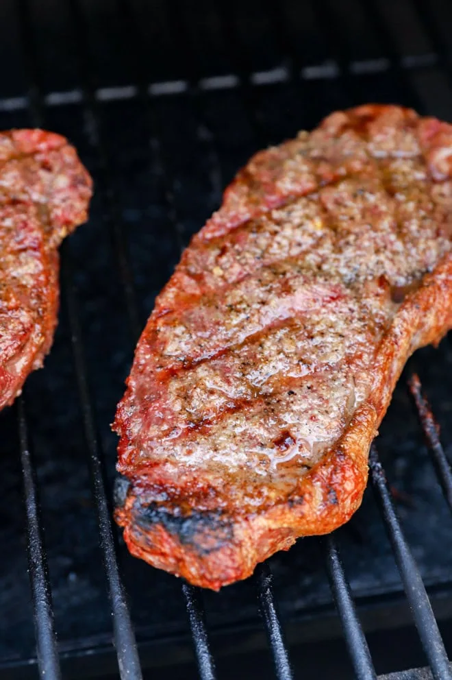 new york strip steak on the grill cooking