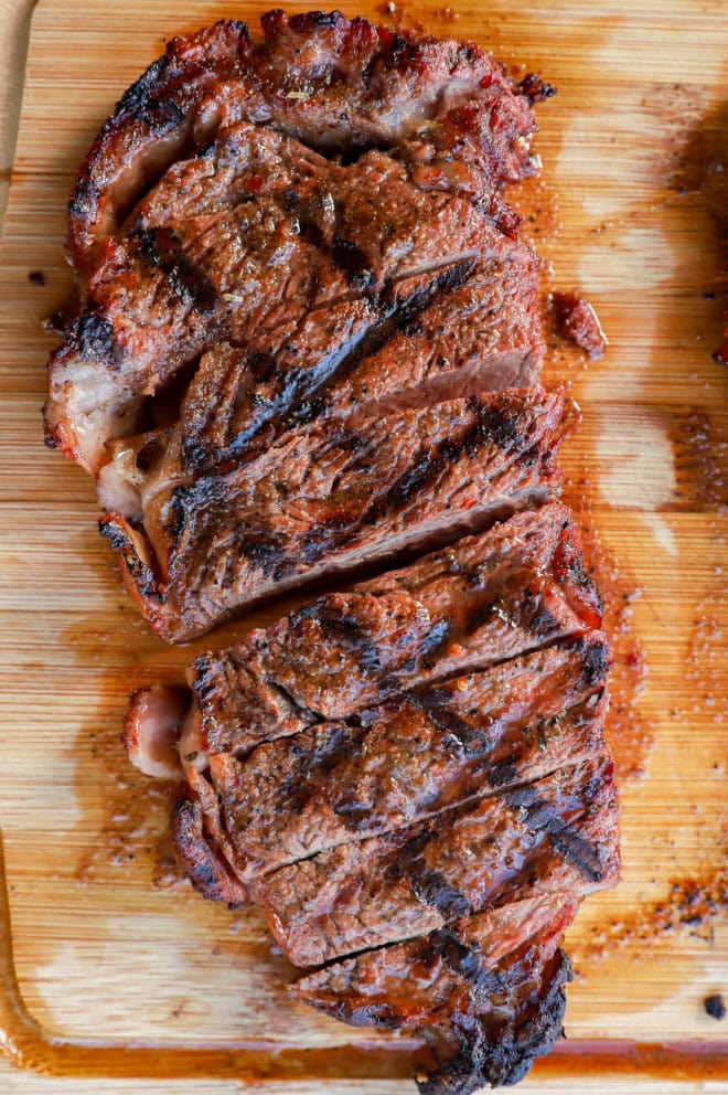 sliced new york strip steak on a cutting board
