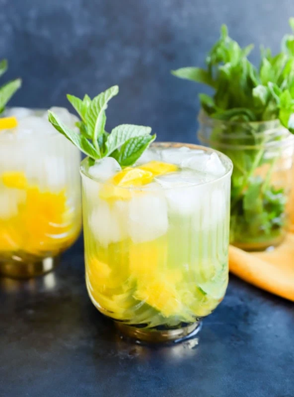 mango mojito in gatsby glasses with mint sprig garnish