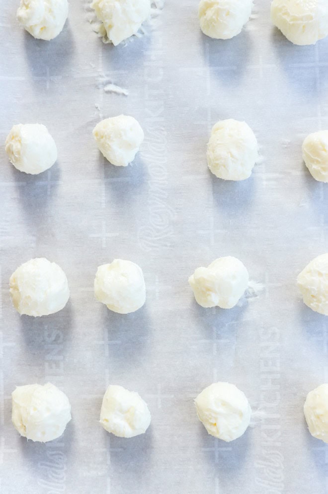 cream cheese filling balls on a baking sheet lined with parchment paper