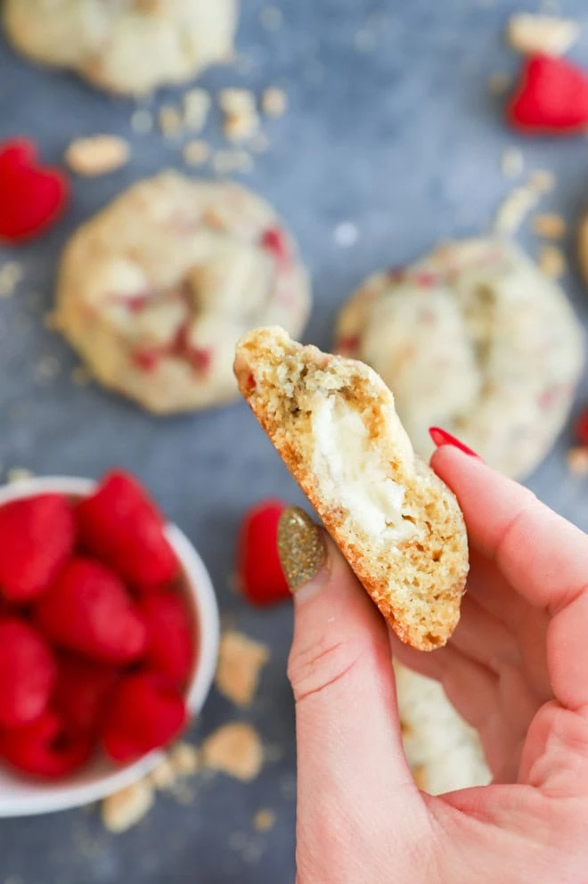 Hand holding half of a fruity cream cheese filled treat
