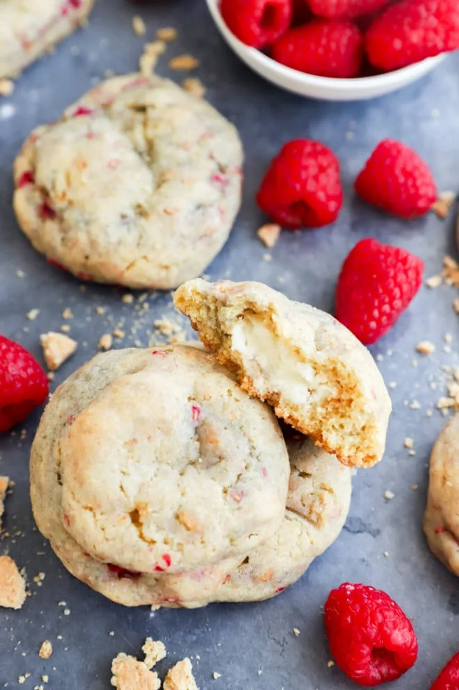 raspberry cheesecake cookies in a stack with fresh raspberries