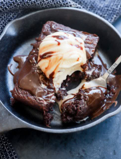 fork taking a bite out of a sizzling brownie ice cream sundae